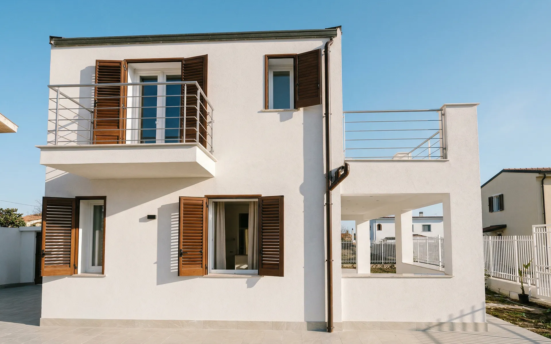 Oltre agli infissi in PVC a battente e agli scorrevoli paralleli con anti-ribalta in finitura noce reale, abbiamo creato un porticato con vetrate scorrevoli.